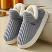 Non slip slippers for women in grey ribbed fleece worn at home on a wood floor