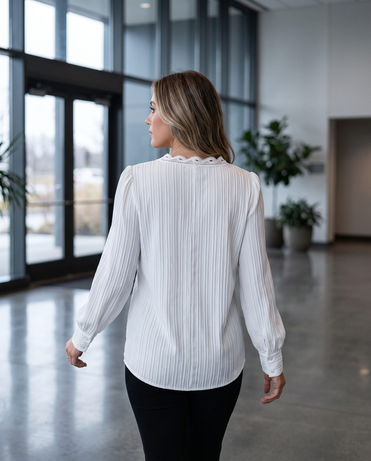 Women's dressy long sleeve work blouse worn walking through an office lobby