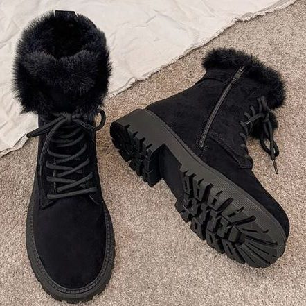Lace up boots for women with faux fur collar and lug sole on a snowy sidewalk