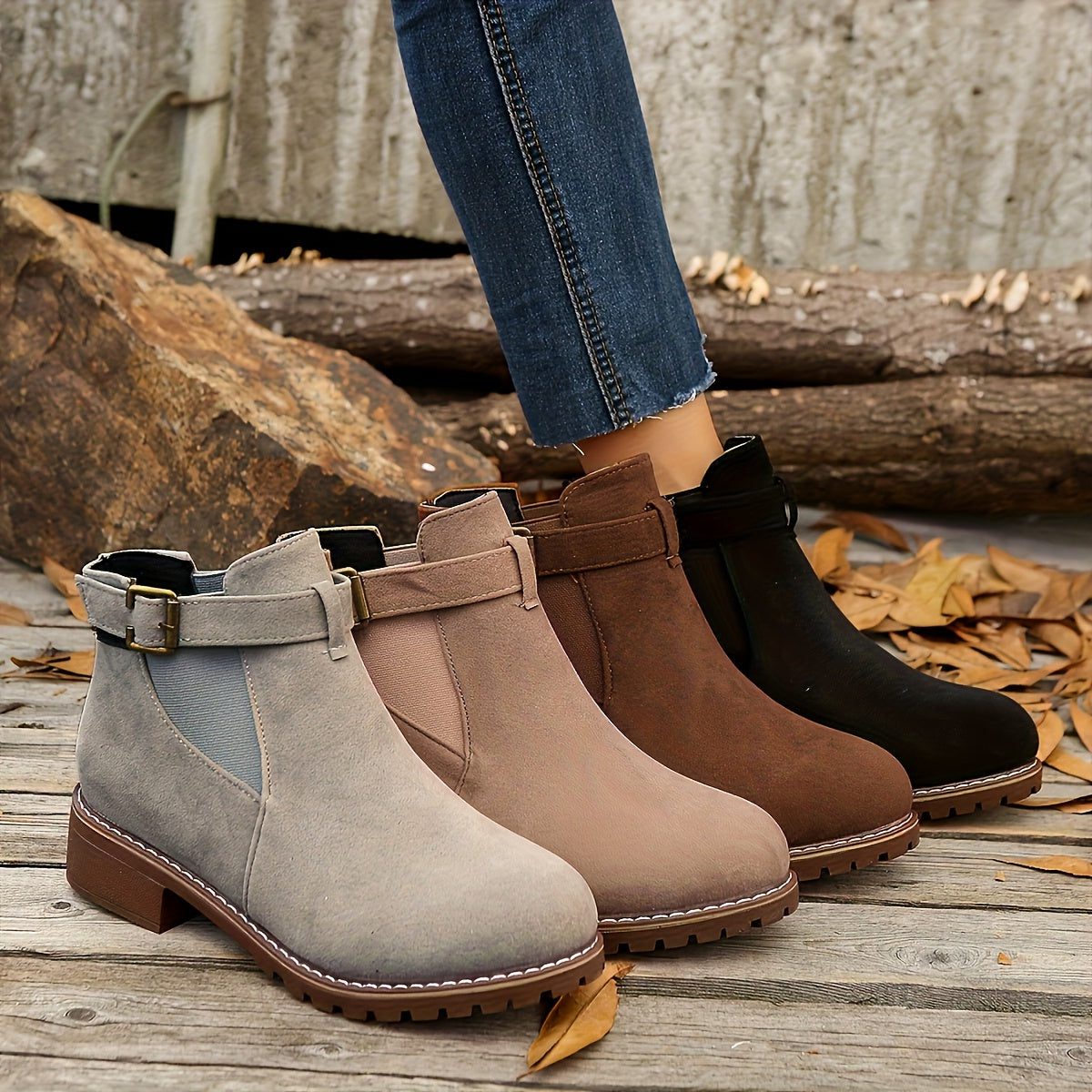 Block heel Chelsea boots for women with buckle strap worn with jeans on a fall sidewalk