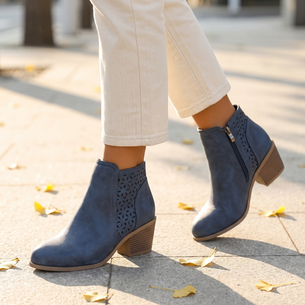 Arch support cutout boots walking on a sunlit sidewalk with fall leaves