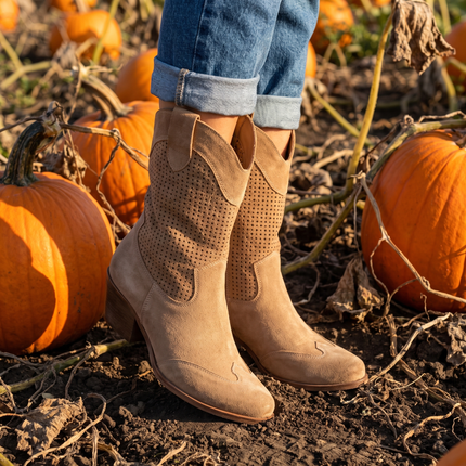 Comfortable cowboy boots for women with arch support, standing in a pumpkin patch
