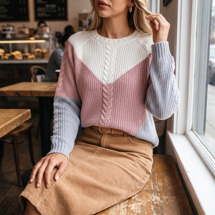 Women's colorblock crew neck sweater in pink, worn with a corduroy skirt
