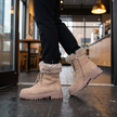 Lace up boots for women in khaki at a cafe entrance